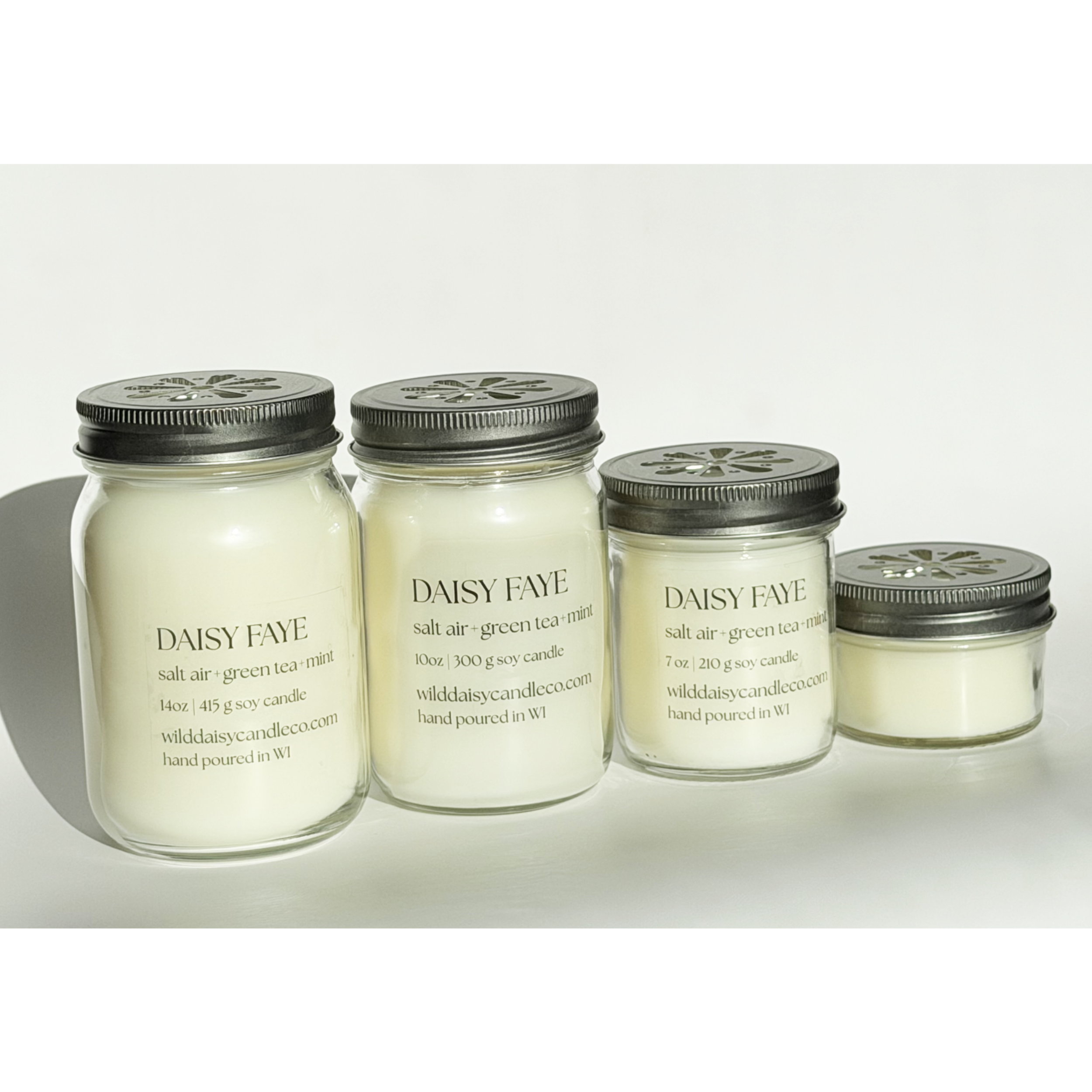 Set of four Daisy Jar candles on a light background